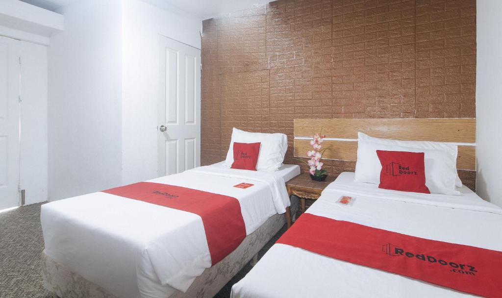 Postel nebo postele na pokoji v ubytování RedDoorz Premium at THE GRAND PENINSULA SUITES