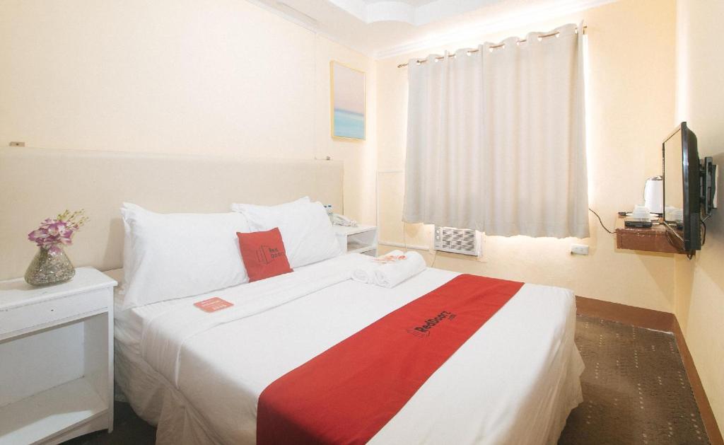 Postel nebo postele na pokoji v ubytování RedDoorz Premium at THE GRAND PENINSULA SUITES