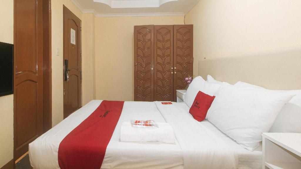 Postel nebo postele na pokoji v ubytování RedDoorz Premium at THE GRAND PENINSULA SUITES
