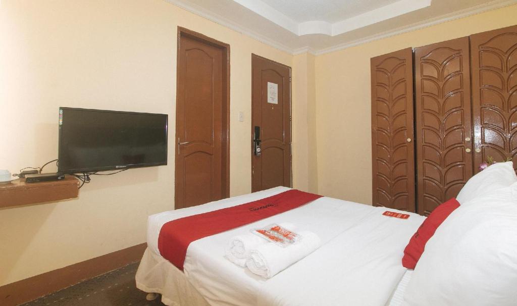 Postel nebo postele na pokoji v ubytování RedDoorz Premium at THE GRAND PENINSULA SUITES