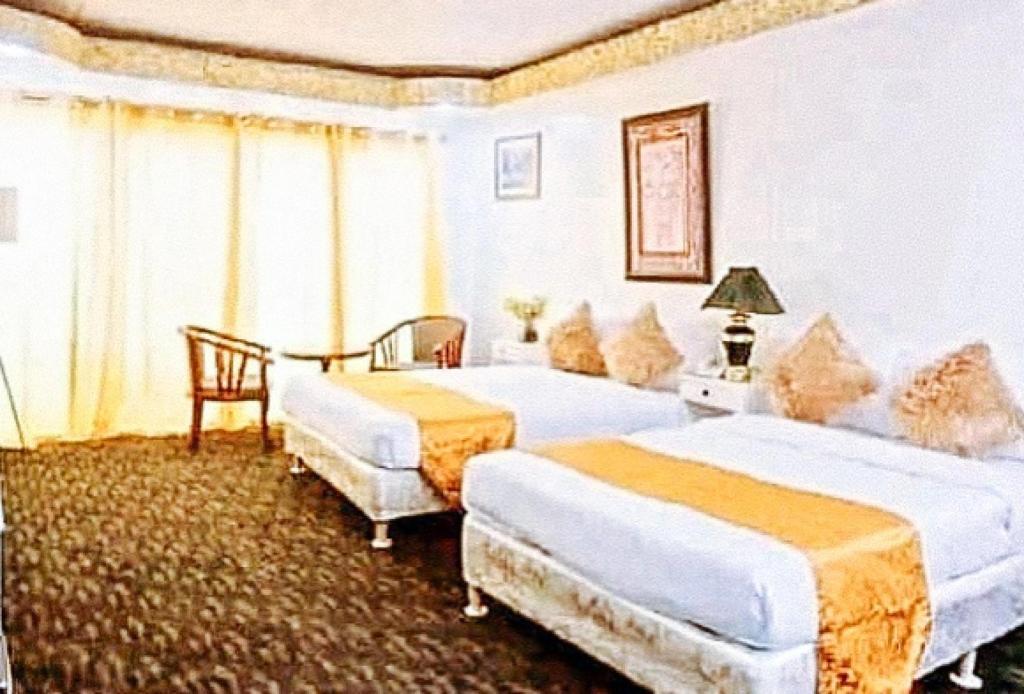 Postel nebo postele na pokoji v ubytování RedDoorz Premium at THE GRAND PENINSULA SUITES