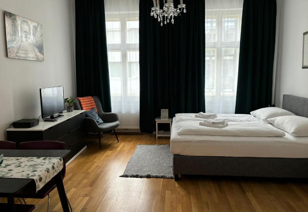 Hotel Casa Nostra - Ruhig & zentral wohnen am Augarten, a bedroom with a bed and a desk and a couch at Casa Nostra - Ruhig & zentral wohnen am Augarten in Vienna