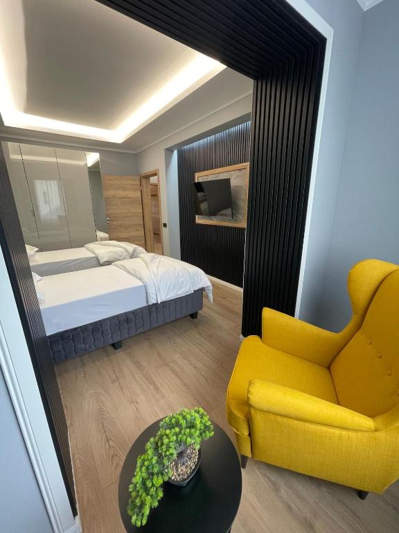 a bedroom with a bed and a yellow chair at Modernes LuxusApartment in Essen in Essen
