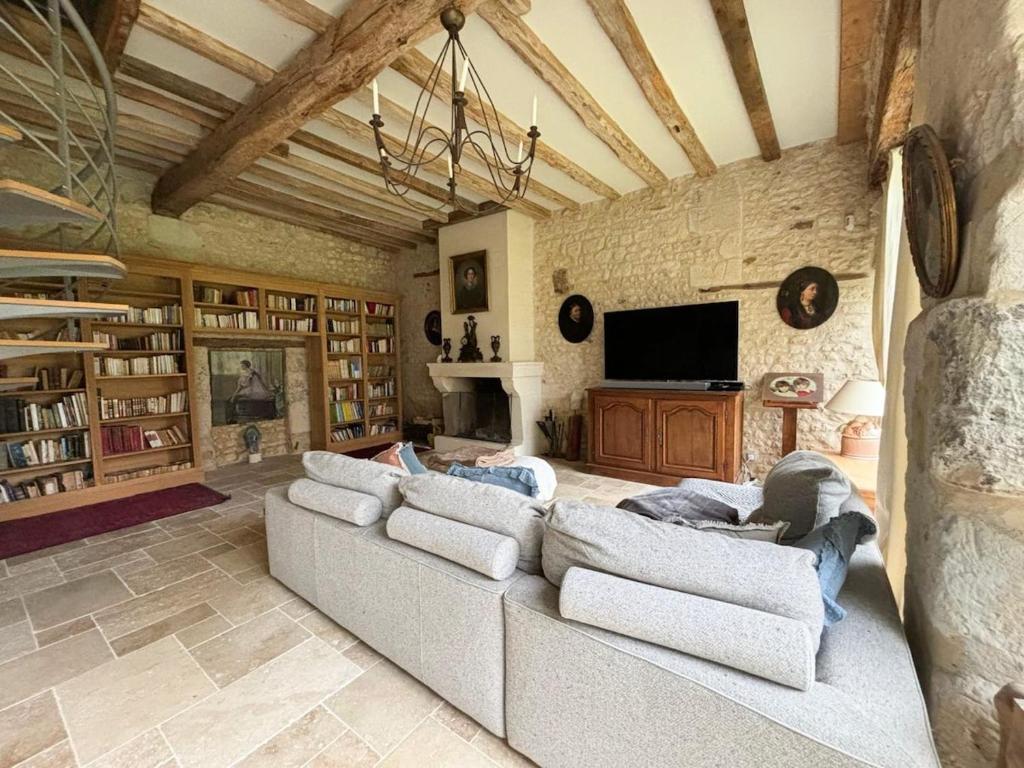 un salon avec deux canapés et une télévision dans l'établissement Belle Grange en pierre avec piscine chauffée, à Saint-ouen-de-la-Cour