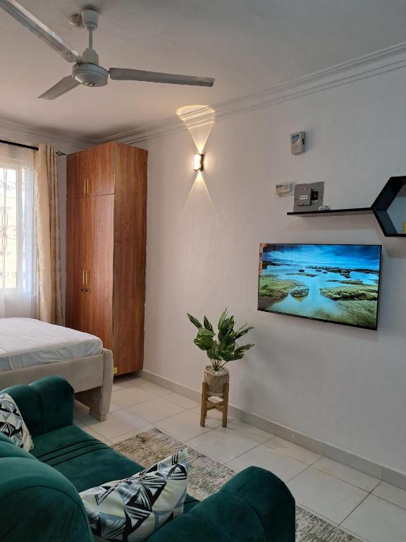 a living room with a bed and a tv on a wall at Phoina Homes in Mombasa
