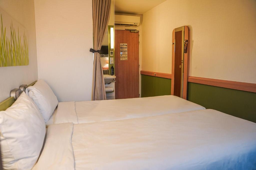 Postel nebo postele na pokoji v ubytování Ibis Budget Bayeux