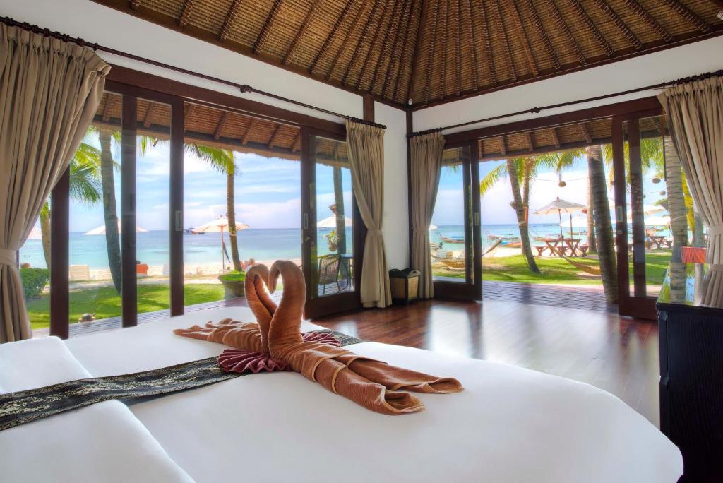 ein Hotelzimmer mit einem Bett und Meerblick in der Unterkunft Mali Resort Pattaya Beach Koh Lipe in Ko Lipe