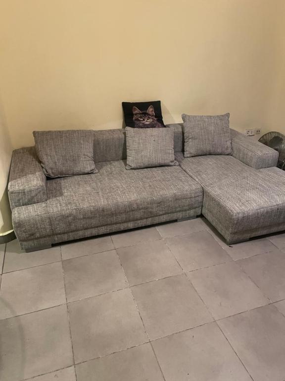 un canapé gris dans une pièce avec un sol carrelé dans l'établissement LE SOLEIL DE MARSEILLE, à Marseille