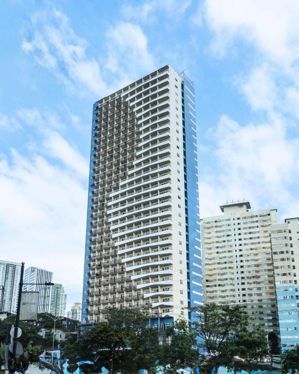 a tall building with a clock on the side of it at Novel Hotel Manila in Manila
