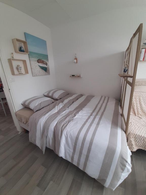 - une chambre avec un lit et une couette à rayures dans l'établissement Appartement 2 pieces, à Jullouville