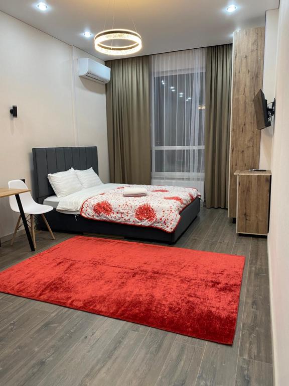 a bedroom with a bed and a red rug at Сардар-1 in Astana
