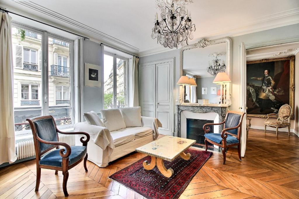 - un salon avec un canapé, des chaises et une cheminée dans l'établissement Parisian Home 277 2 chambres Marais - Bastille, à Paris
