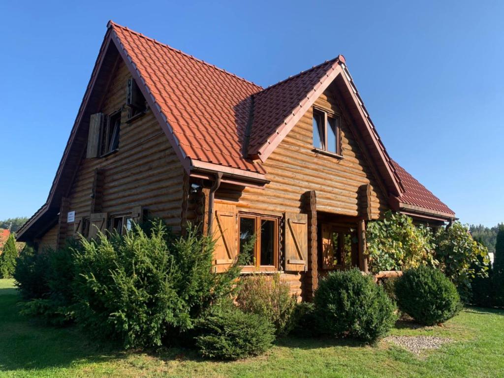 a wooden house with a red roof at Najtańsze domki na Mazurach Krutyń Giżycko Mikołajki Mrągowo Ostróda rezerwacje wyłącznie telefonicznie 512-29O-43O prosimy nie sugerować się dostępnością domków na tej stronie zapraszamy www domkiwkrutyni com in Krutyń