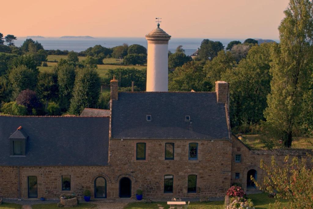 an old building with a lighthouse on top of it at Les écolodges Sous Le Phare in Louannec