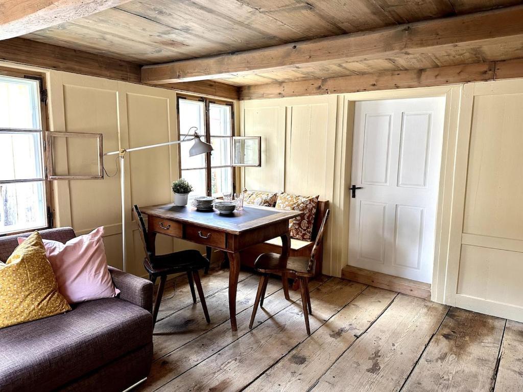 a living room with a table and a couch at Private Apartment in Guesthouse Rosalie in Brunnadern