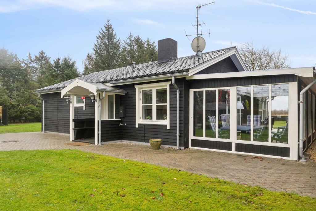 a black house with a lot of windows at Lovely Holiday Home By The Limfjord in Storvorde
