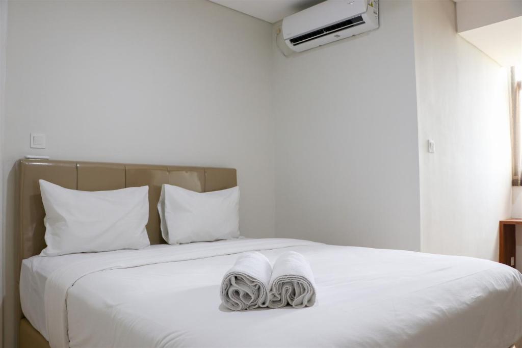 Кровать или кровати в номере Homey and Comfort Living 2BR at Daan Mogot City Apartment By Travelio