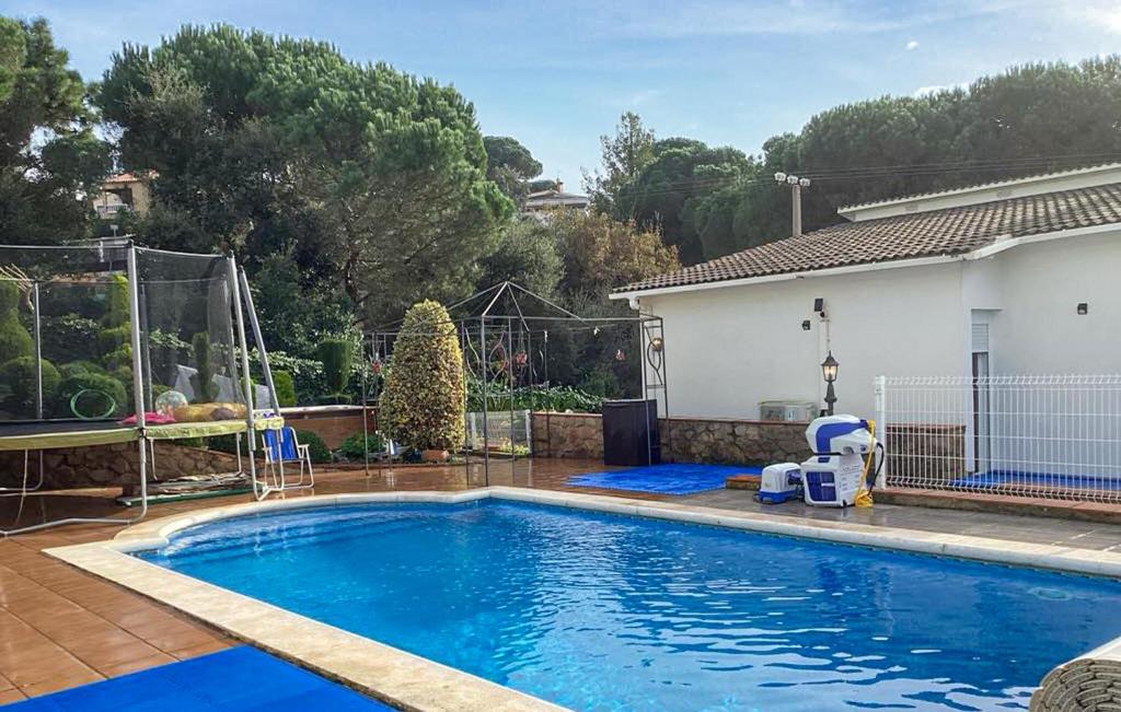 a swimming pool in the backyard of a house at Pet Friendly Home In Vidreres in Vidreres