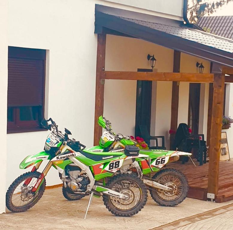 a green motorcycle parked in front of a garage at Visoravan 1200 in Kupres