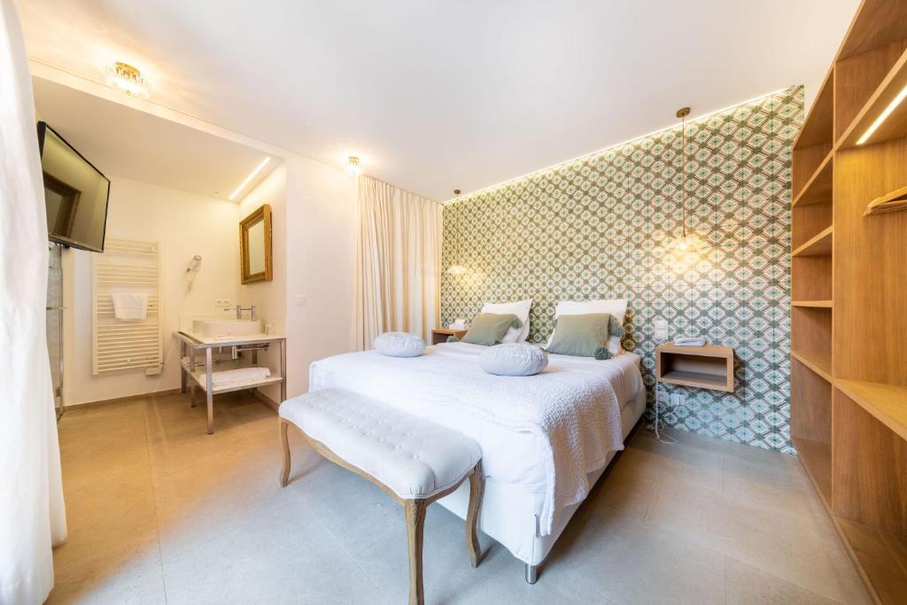 a bedroom with a bed and a desk and a sink at Les Capucines Saint Tropez in Saint-Tropez