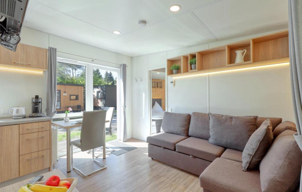 a living room with a couch and a kitchen at Tiny Haus im Waldcamping am Brombachsee in Pleinfeld