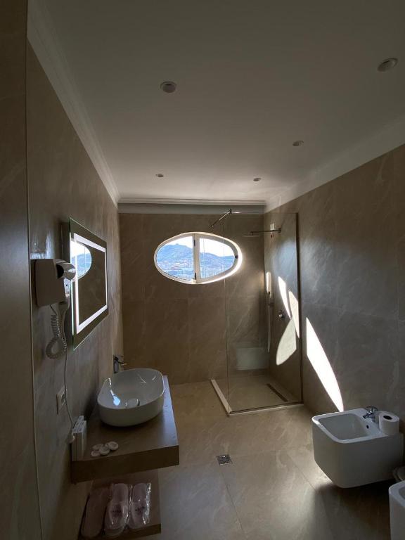 Hotel Eiffel في تيرانا: حمام مع حوض ومرحاض ونافذة