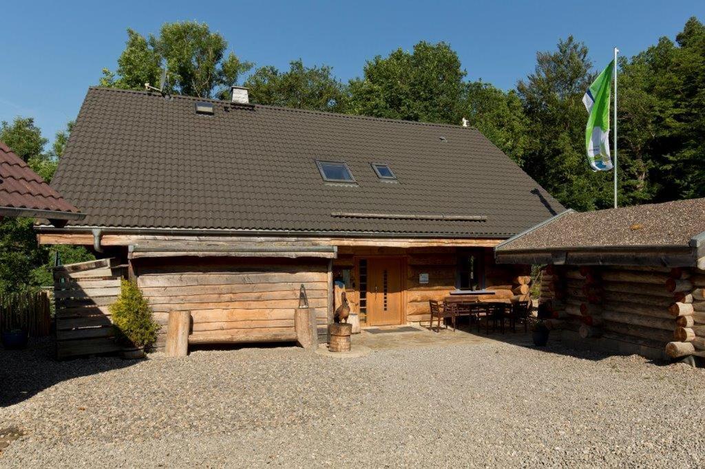 une cabane en rondins avec un drapeau au-dessus de celle-ci dans l'établissement Eifelurlaub - kanadisches Blockstamm Ferienhaus für 12 Personen, à Schleiden