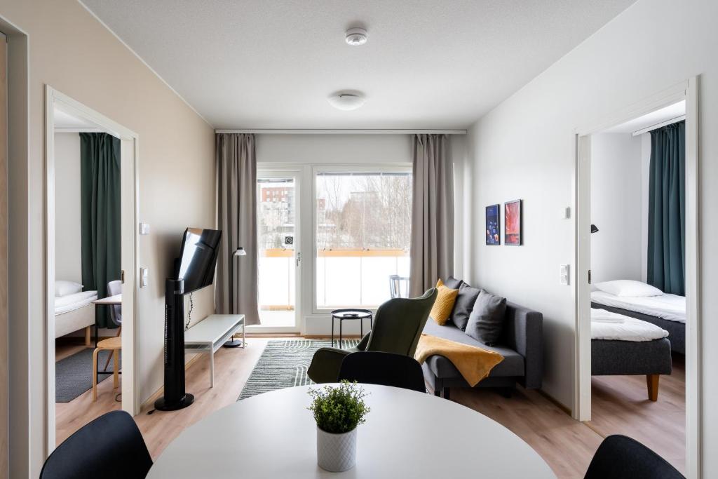 a living room with a bed and a table and chairs at Hiisi Homes Kirkkonummi Masala Salmipolku in Masala
