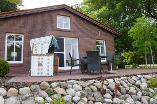 a brick house with a table and chairs in front of it at Apartment Abendsonne Mit Eigener Terrasse in Klein Meckelsen