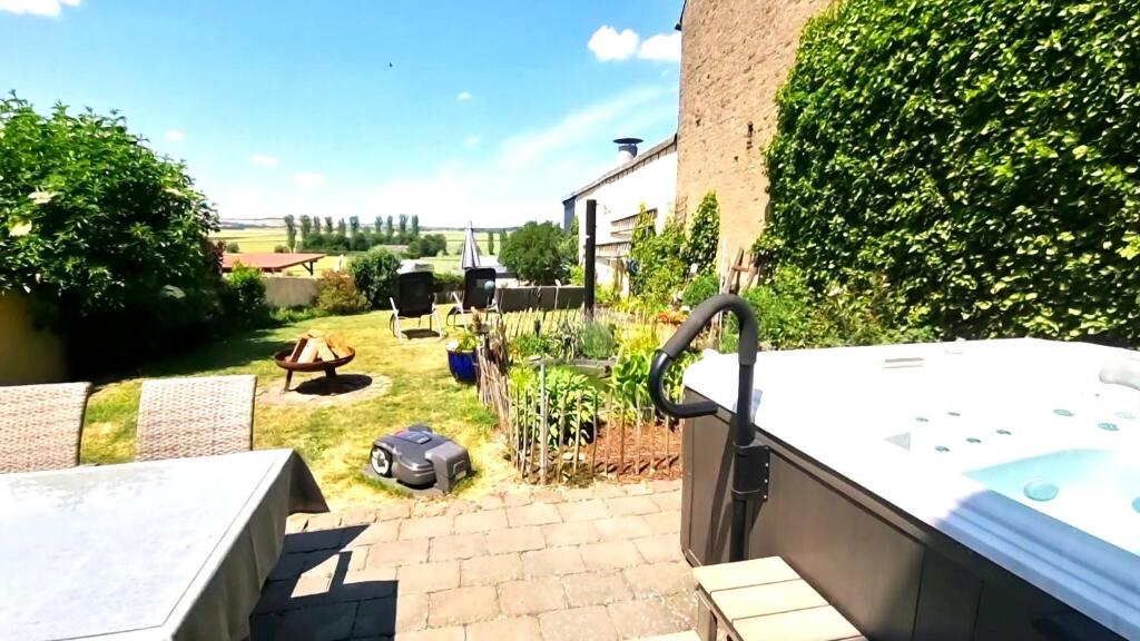 a backyard with a hot tub and a garden at Ferienhaus Maifelder Wellness Loft In Gappenach in Gappenach
