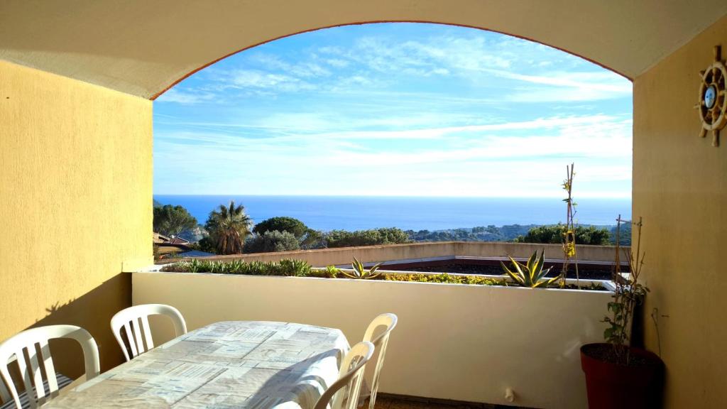 une table et des chaises sur un balcon avec vue sur l'océan dans l'établissement Terrazzo - 1 chambre, vue sur la mer et piscine, à Cassis