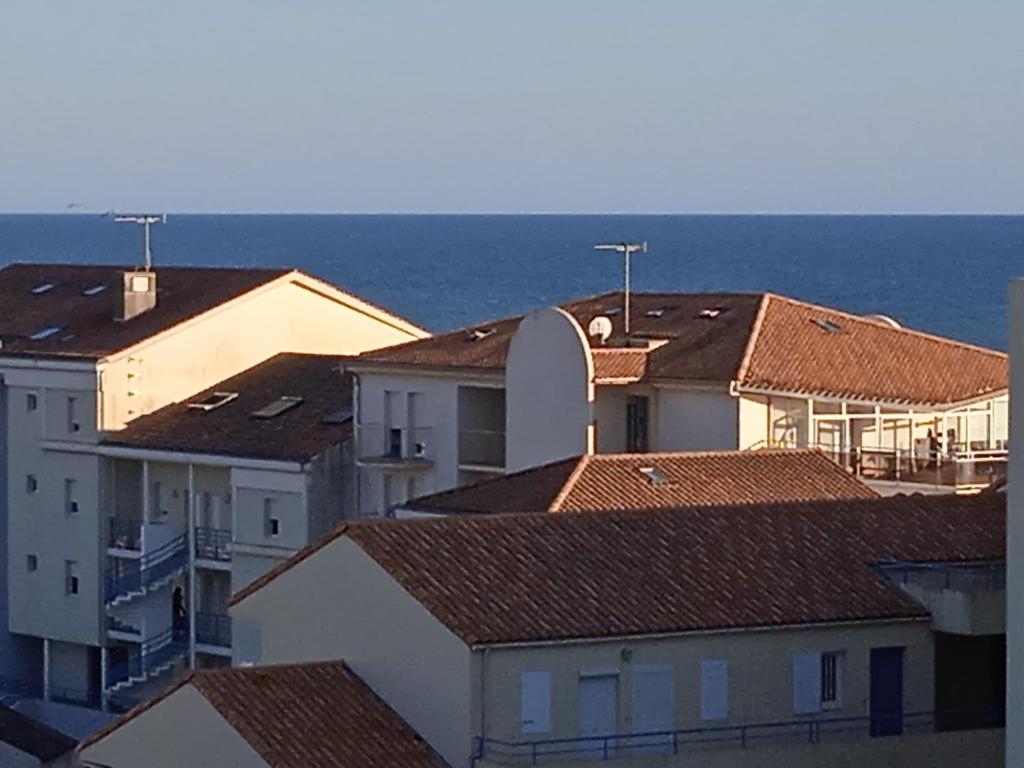 un groupe de bâtiments avec l'océan en arrière-plan dans l'établissement A deux pas de la plage, à Saint-Hilaire-de-Riez