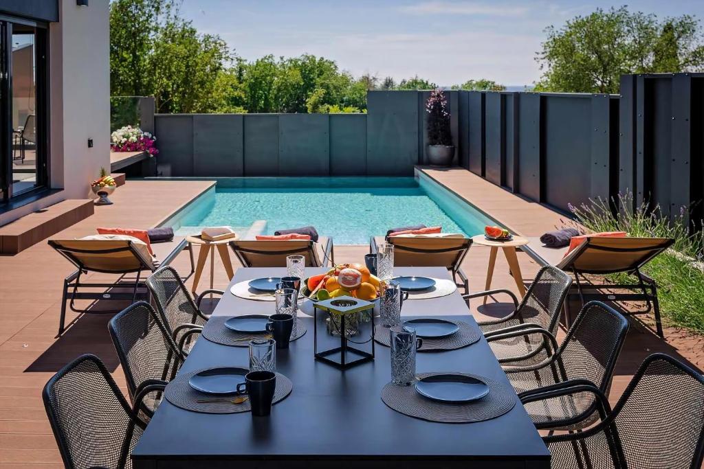 eine Terrasse mit einem Tisch und Stühlen neben einem Pool in der Unterkunft Ferienhaus mit Privatpool für 6 Personen ca 200 m in Poreč, Istrien Istrische Riviera in Poreč