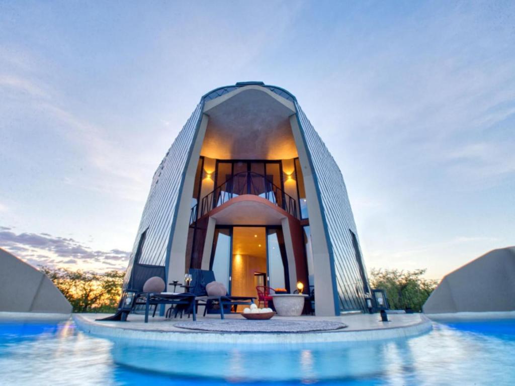 a house with a swimming pool in the middle of the water at The Ekipa in Okaukuejo