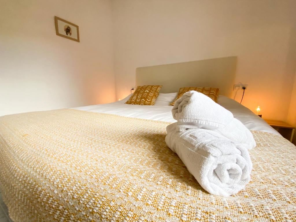 a pile of towels sitting on top of a bed at El Penell Apartament Xaloc in Vilamaniscle