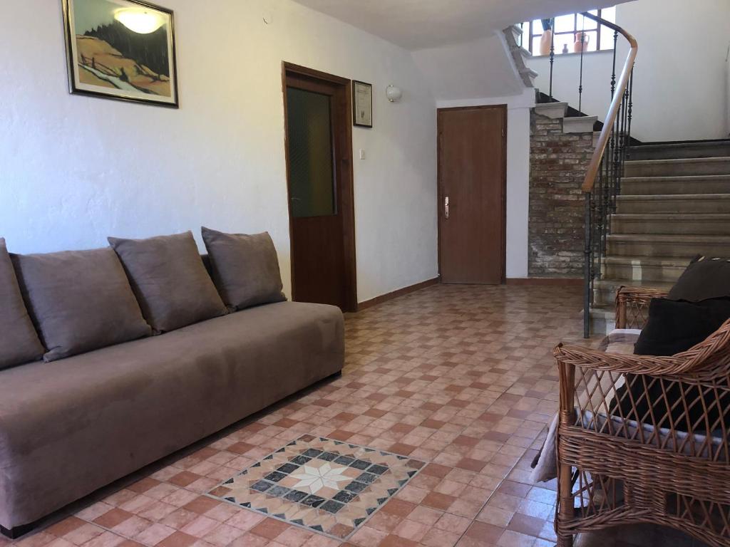 a living room with a couch and a staircase at Holiday House in Roč