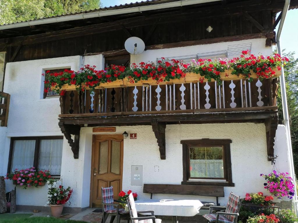 ein Haus mit einem Balkon mit Blumen darauf in der Unterkunft Ruhig am Waldrand gelegene Wohneinheit in Innsbruck