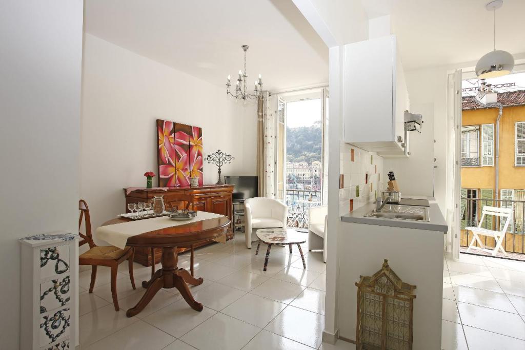 une cuisine et une salle à manger avec une table et des chaises dans l'établissement AIGUE-MARINE - Superbe appartement Vue Mer 4 personnes au Port de Nice, à Nice