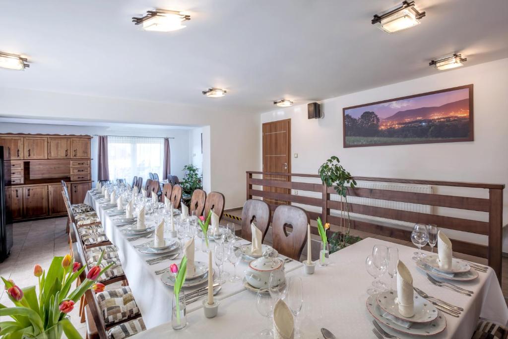 długa jadalnia z długim stołem i krzesłami w obiekcie Hotel Kolonie w mieście Frydlant nad Ostrawicą