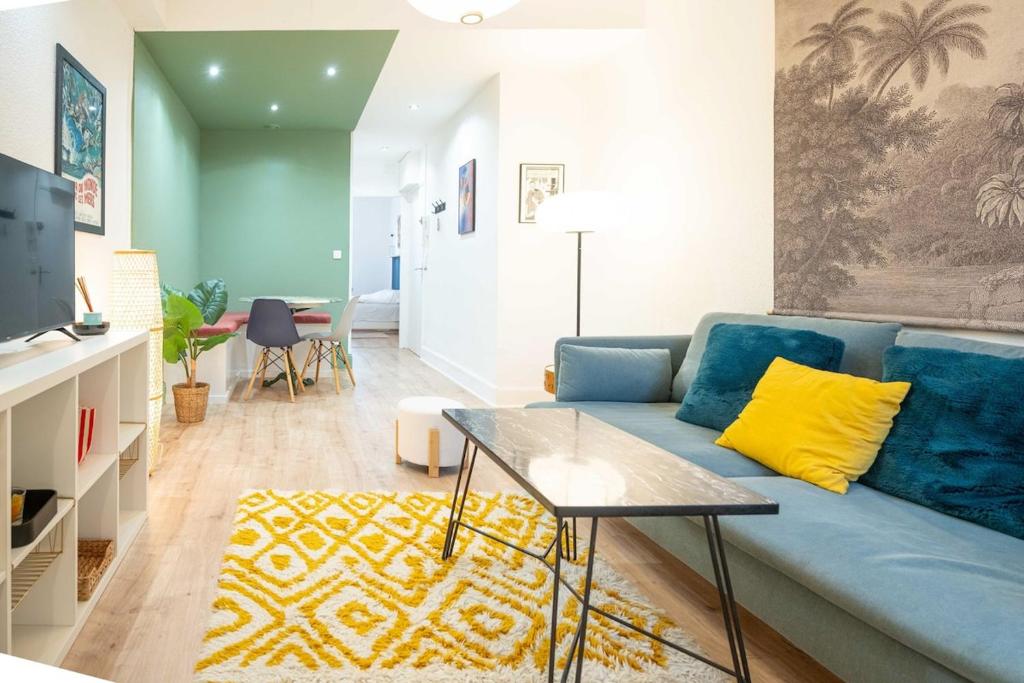 - un salon avec un canapé bleu et des oreillers jaunes dans l'établissement Nancy Cure Thermale SPECIAL CURISTES - Artem - Parc Ste-Marie - RDC BLEU, à Nancy