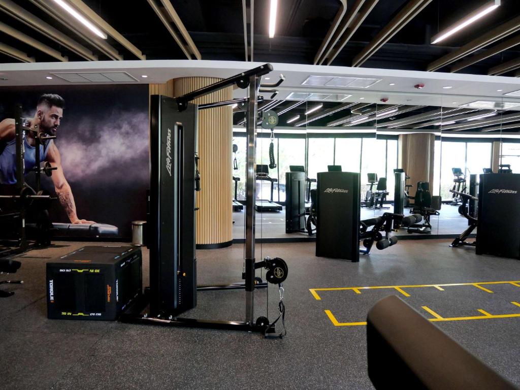a room with a gym with a man on the wall at Pullman Phuket Karon Beach Resort in Karon Beach