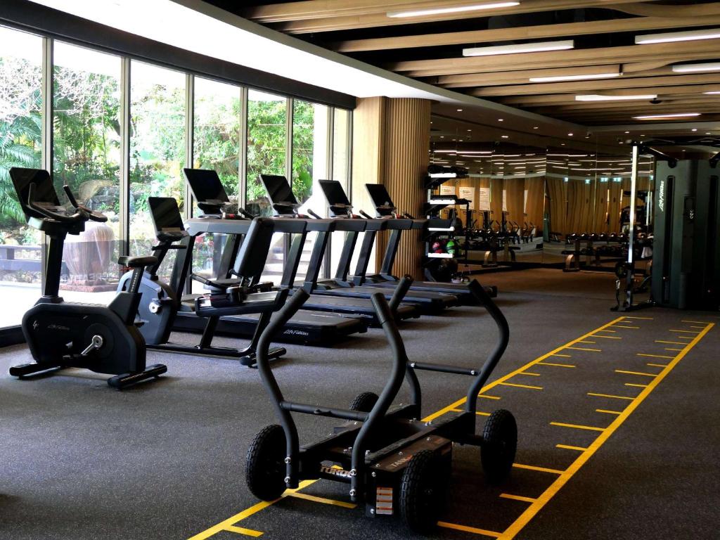 a gym with rows of cardio bikes and treadmills at Pullman Phuket Karon Beach Resort in Karon Beach