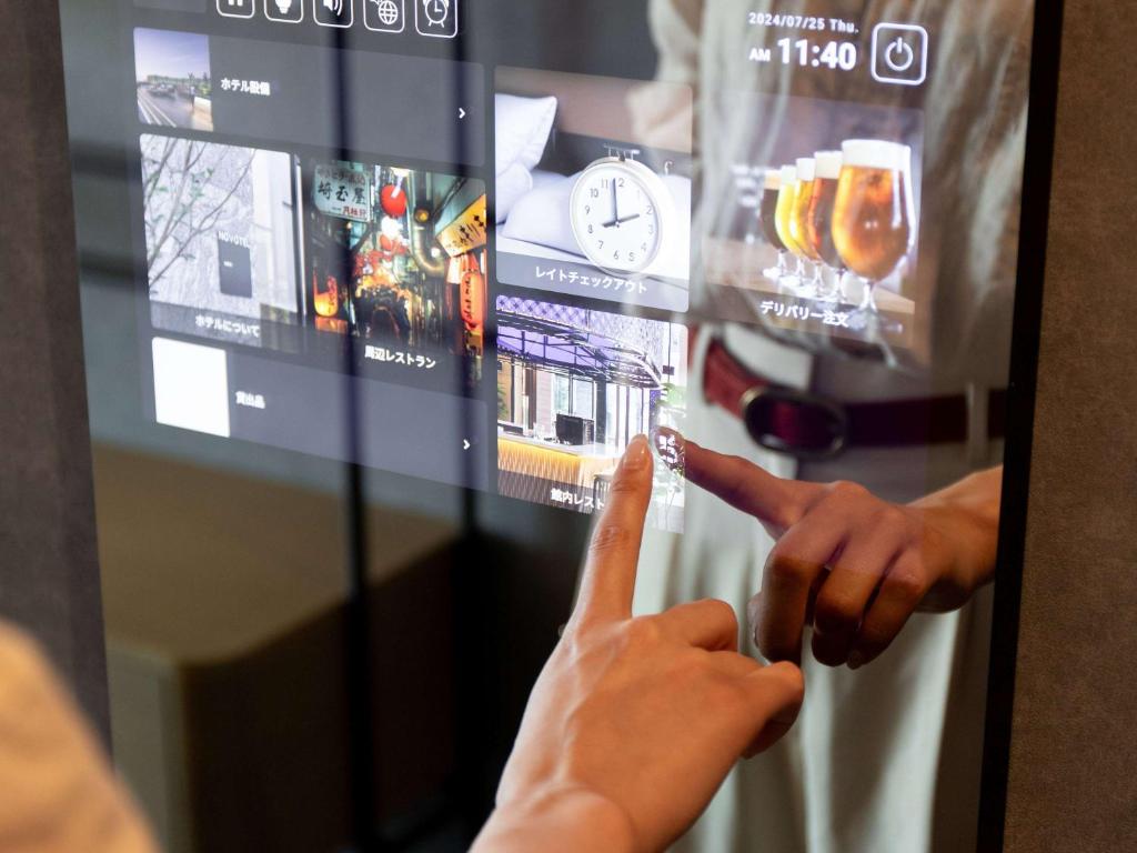 a person is pointing at a screen with their hand at Novotel Nara in Nara