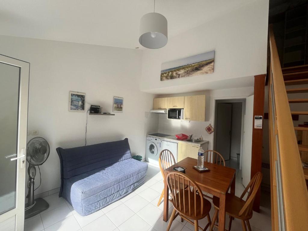 a living room with a blue couch and a table at appartement dans un residence avec piscine - 3254 in Hourtin