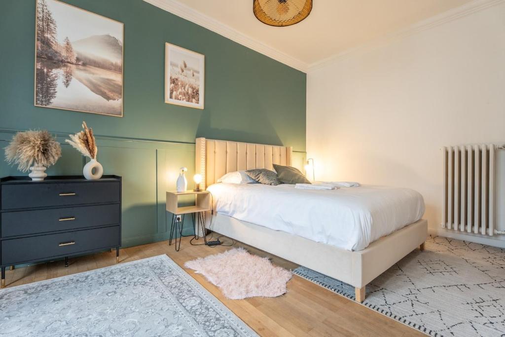 une chambre avec un lit et un mur bleu dans l'établissement Mulhouse parking gratuit Centre, à Mulhouse