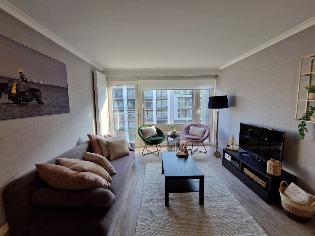 ein Wohnzimmer mit Sofa und Tisch in der Unterkunft Premium Holidays - Studio Vriedom at the sea in Oostduinkerke
