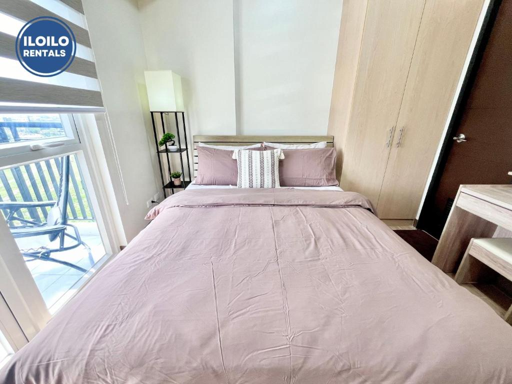 a large bed with pink sheets in a room at Room in Condo - Cozy, Modern and Homey, The Bliss Studio in Iloilo City