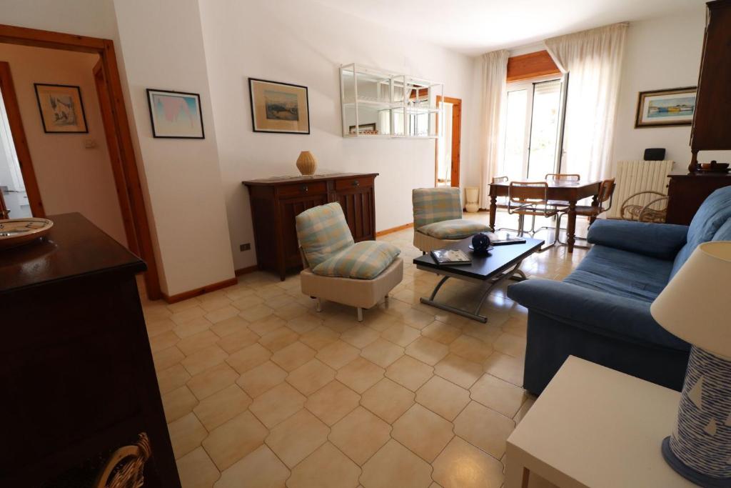 a living room with a blue couch and chairs at Charming Otranto Apartment Turchese Air Con Covered Parking in Otranto
