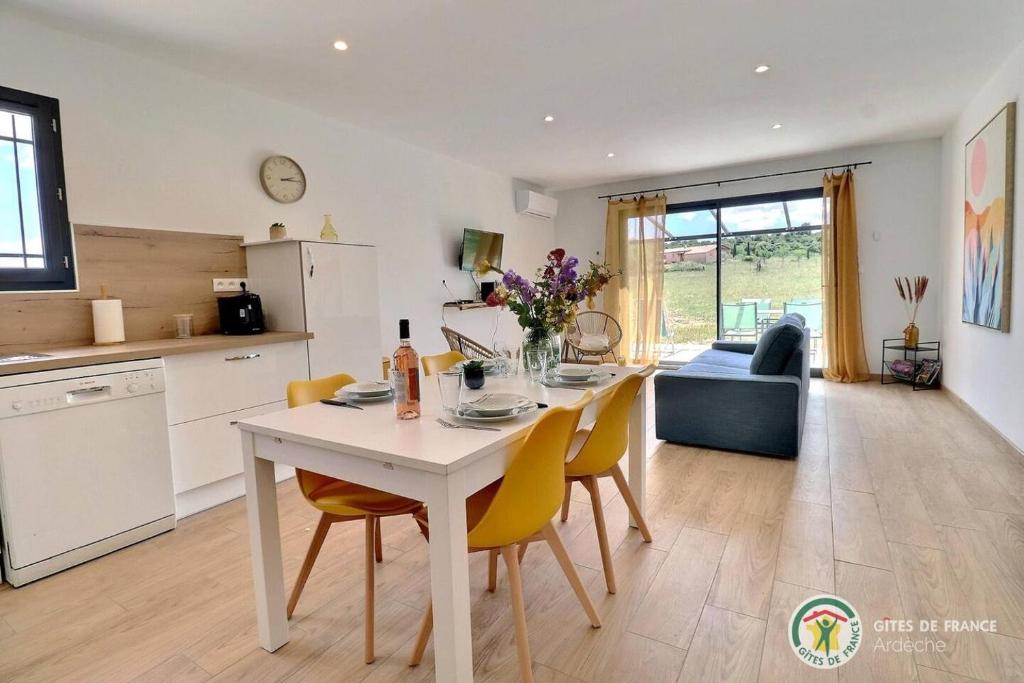 une cuisine et un salon avec une table et des chaises dans l'établissement Le Bonelli, au coeur de l'Ardèche, à Saint-Remèze