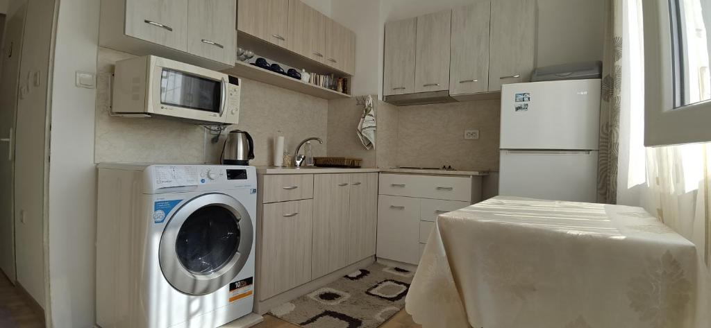 una cocina con lavadora y nevera en Апартамент Калоян, en Banya